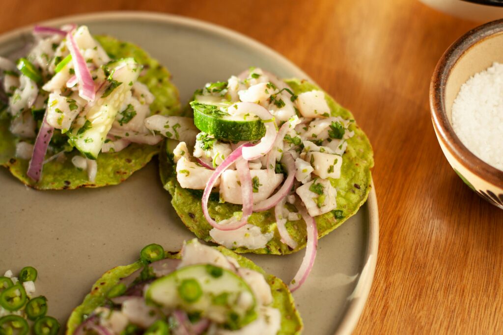 Mexican tostadas with fresh vegetables and herbs on a plate, perfect for food photography.